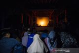 Warga melihat pentas wayang kulit Banjar mempertunjukan wayang sampir saat pergelaran budaya di Taman Wisata Pagat, Barabai, Kabupaten Hulu Sungai Tengah, Kalimantan Selatan, Senin (18/10/2021). Pertunjukan wayang sampir tersebut bertujuan untuk suatu hajat tertentu yang disebut manyampir, merupakan ritual yang dipimpin oleh dalang untuk mengusir roh-roh jahat yang menggangu kehidupan manusia serta menjadi hiburan bagi masyarakat. Foto Antaranews Kalsel/Bayu Pratama S.