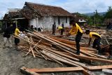 Sejumlah personel polisi dan TNI membersihkan reruntuhan rumah yang roboh akibat puting beliung di Desa Sumberbendo, Saradan, Kabupaten Madiun, Jawa Timur, Senin (18/10/2021). Puting beliung menyertai hujan di wilayah tersebut mengakibatkan tiga rumah warga roboh dan ratusan rusak serta banyak pohon tumbang, Minggu (17/10). Antara Jatim/Siswowidodo/zk