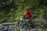 Warga menggunakan motor trail melintas di Sungai Kapiyau di Dusun Pantai Mangkiling, Kecamatan Hantakan, Kabupaten Hulu Sungai Tengah, Kalimantan Selatan, Selasa (19/10/2021). Pengelola wisata Pedalaman Pegunungan Meratus (P2M) membuka jalur wisata jelajah hutan Pegunungan Meratus bagi penghobi dan penggiat motor trail yang ingin merasakan sensai jalur sungai hingga menuju beberapa air terjun yang ada di kawasan wisata tersebut. Foto Antaranews Kalsel/Bayu Pratama S.