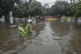 Dua warga menerobos genangan air di Rawalumbu, Bekasi, Jawa Barat, Senin (18/10/2021).Intesitas hujan yang tinggi di wilayah tersebut menyebabkan genangan air setinggi 80 cm akibat saluran drainase yang buruk. ANTARA FOTO/ Fakhri Hermansyah/rwa.