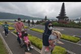 Wisatawan menikmati pemandangan objek wisata Ulun Danu Beratan saat liburan Maulid Nabi Muhammad SAW di Tabanan, Bali, Rabu (20/10/2021). Jumlah kunjungan wisatawan di objek wisata tersebut mengalami peningkatan dengan rata-rata 300 orang pada hari libur dan 100 orang pada hari biasa yang didominasi wisatawan domestik sejak dibuka pada Jumat (10/9/2021). ANTARA FOTO/Nyoman Hendra Wibowo/nym.