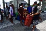 Pembatasan Pemgelian Solar di Madiun. Warga mengangkut drum kaleng berisi Bahan Bakar Minyak (BBM) solar di sebuah Stasiun  Pengisian Bahan Bakar Umum (SPBU) di Kota Madiun, Jawa Timur, Selasa (19/10/2021). Sejak tiga hari terakhir SPBU tersebut membatasi layanan pembelian solar paling banyak Rp200 ribu setiap pembelian baik untuk kendaraan, pengecer maupun keperluan mesin pompa air irigasi pertanian, yang menurut petugas karena adanya pembatasan pasokan dari PT Pertamina. Pembatasan pembelian solar juga terjadi di sejumlah SPBU lain di wilayah Kota dan Kabupaten Madiun. Antara Jatim/Siswowidodo/zk