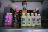 Peternak menunjukan produk olahan susu kambing etawa di koperasi Pondok Pesantren Al Urwatul Wutsqo, Sindang, Indramayu, Jawa Barat, Rabu (20/10/2021). Permintaan susu kambing etawa mengalami peningkatan hingga 50 persen di masa pandemi COVID-19 dengan pesanan ke sejumlah daerah di Jawa Barat. ANTARA FOTO/Dedhez Anggara/agr
