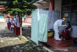 Petugas kesehatan melakukan tes pcr kepada seorang siswa di SDN 025 Cikutra, Bandung, Jawa Barat, Jumat (22/10/2021). Dinas Kesehatan Kota Bandung mencatat, hingga Kamis (21/10/2021) sebanyak 54 pelajar dan guru di berbagai sekolah di Kota Bandung dinyatakan positif COVID-19 hasil dari tes usap PCR secara acak yang dilakukan sejak 15 oktober hingga 19 Oktober 2021. ANTARA FOTO/Raisan Al Farisi/agr
