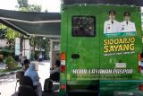 Warga mengantre untuk membuat paspor di mobil layanan paspor saat diluncurkan di Pondok Pesantren Modern AlAmanah di Junwangi, Krian, Sidoarjo, Jawa Timur, Jumat (22/10/2021). Mobil layanan paspor tersebut bertujuan untuk mempermudah masyarakat membuat paspor di tengah pandemi COVID-19 dengan pembatasan kuota permohonan paspor hingga 20 orang dalam sehari. Antara Jatim/Umarul Faruq/zk