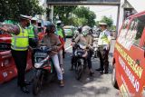  Polisi melakukan pemeriksaan ke pengendara motor yang melintas di jalan Raya Waru, Perbatasan Surabaya - Sidoarjo, Jawa Timur, Jumat (22/10/2021). Polresta Sidoarjo menyiagakan tiga gerai mobil vaksin keliling dan bus vaksin mobile di perbatasan untuk memfasilitasi warga yang belum tervaksin sebagai upaya mendukung percepatan program vaksinasi COVID-19. Antara Jatim/Umarul Faruq/zk