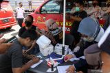  Petugas melakukan pendataan dan vaksinasi kepada pengendara motor yang belum tervaksin saat melintas di jalan Raya Waru, Perbatasan Surabaya - Sidoarjo, Jawa Timur, Jumat (22/10/2021). Polresta Sidoarjo menyiagakan tiga gerai mobil vaksin keliling dan bus vaksin mobile di perbatasan untuk memfasilitasi warga yang belum tervaksin sebagai upaya mendukung percepatan program vaksinasi COVID-19. Antara Jatim/Umarul Faruq/zk