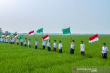 Santri mengibarkan bendera merah putih dan Nahdlatul Ulama saat mengikuti kirab santri di Desa Ciwulan, Telagasari, Karawang, Jawa Barat, Senin (25/10/2021). Kegiatan yang diikuti ratusan santri, Barisan Ansor Serbaguna (Banser) dan Ikatan Pelajar Nahdlatul Ulama (IPNU) itu dalam rangka memperingati hari lahir PCNU Karawang ke-84 dan Hari Santri Nasional 2021. ANTARA FOTO/M Ibnu Chazar/agr