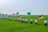 Santri mengibarkan bendera Merah Putih dan Nahdlatul Ulama saat mengikuti kirab santri di Desa Ciwulan, Telagasari, Karawang, Jawa Barat, Senin (25/10/2021). Kegiatan yang diikuti ratusan santri, Barisan Ansor Serbaguna (Banser) dan Ikatan Pelajar Nahdlatul Ulama (IPNU) itu dalam rangka memperingati hari lahir PCNU Karawang ke-84 dan Hari Santri Nasional 2021. ANTARA FOTO/M Ibnu Chazar/rwa.