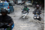 Pengendara motor menerobos banjir di Jalan Raya Kebayoran Lama, Jakarta, Senin (25/10/2021). Banjir yang menggenangi jalan setinggi lutut orang dewasa itu disebabkan karena drainase buruk saat terjadi hujan deras. ANTARA FOTO/Muhammad Iqbal/rwa.
