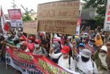 Sejumlah petani yang tergabung dalam Kelompok Tani Maju Makmur Desa Babadan melakukan unjuk rasa di depan gedung Pemkab Kediri, Jawa Timur, Rabu (27/10/2021). Aksi ratusan petani lereng gunung Kelud tersebut untuk mengawal dengar pendapat bersama DPRD terkait rencana pengajuan permohonan kepada presiden tentang penetapan pengembalian hak atas lahan warga desa Babadan seluas 124 hektar yang dikuasai oleh PT Perkebunan Nusantara IX Ngrangkah Sepawon. Antara Jatim/Prasetia Fauzani/zk