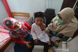 Bulan imunisasi anak sekolah Aceh. Petugas Puskesmas Ulee Kareng memberikan imunisasi pencegahan campak, difteri dan tetanus kepada pelajar pada program Bulan Imunisasi Anak Sekolah (BIAS) di SD Negeri 42 Lamteh, Banda Aceh, Aceh, Jumat (29/10/2021). Pemberian imunisasi bagi pelajar sekolah dasar merupakan komitmen Kementerian Kesehatan untuk meningkatkan kualitas sumber daya manusia melalui Usaha Kesehatan Sekolah (UKS) serta upaya preventif untuk memberikan perlindungan kesehatan, mencegah penyakit dan memutus mata rantai penularan dengan pemberian vaksin kekebalan tubuh. Antara Aceh/Irwansyah Putra