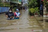 Warga berjalan pada genangan banjir di Dayeuhkolot, Kabupaten Bandung, Jawa Barat, Rabu (3/11/2021). Sedikitnya tiga kecamatan di kawasan Bandung Selatan terdampak banjir dengan ketinggian air 10cm hingga 140cm akibat luapan Sungai Citarum dan intensitas curah hujan yang tinggi. ANTARA FOTO/Novrian Arbi/agr