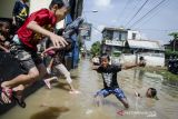 Sejumlah anak bermain pada genangan pada banjir di Dayeuhkolot, Kabupaten Bandung, Jawa Barat, Rabu (3/11/2021). Sedikitnya tiga kecamatan di kawasan Bandung Selatan terdampak banjir dengan ketinggian air 10cm hingga 140cm akibat luapan Sungai Citarum dan intensitas curah hujan yang tinggi. ANTARA FOTO/Novrian Arbi/agr