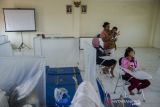 Warga bercengkrama pada pengungsian banjir di Balai Desa Dayeuhkolot, Kabupaten Bandung, Jawa Barat, Rabu (3/11/2021). Pengungsian yang dibuat memiliki sekat untuk mencegah terpapar COVID-19 tersebut telah diisi sedikitnya 32 jiwa sedangkan sebagian warga masih bertahan di rumah yang terdampak banjir Bandung Selatan. ANTARA FOTO/Novrian Arbi/agr