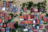 Foto udara suasana permukiman warga yang terendam banjir di Desa Karangligar, Karawang, Jawa Barat, Jumat (5/11/2021). Banjir yang melanda di wilayah itu disebabkan meluapnya air sungai Cibeet karena tingginya intensitas hujan yang mengakibatkan ratusan rumah terendam banjir. ANTARA FOTO/M Ibnu Chazar/agr