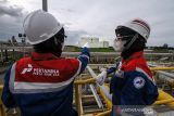 Mendorong tangki LNG PAG menjadi pusat LNG hub Asia. Pekerja PT Perta Arun Gas (PAG) mengamati tangki penyimpanan LNG masing-masing berkapasitas 127.000 m3 di area kilang Terminal penerimaan dan regasifikasi LNG di Desa Blang Lancang, Lhokseumawe, Aceh, Kamis (4/12/2021). Subholding Gas Pertamina Group, PT Perta Arun Gas berinovasi dan berkomitmen mendorong 4 unit tangki LNG Hub Kilang Arun berkapasitas total 508.000 m3 menjadi pusat LNG Hub Asia. ANTARA FOTO/Rahmad