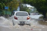 Banda Aceh Banjir Akibat Drainase Buruk. Sejumlah kendaraan menerobos jalan raya yang tergenang banjir akibat curtah hujan tinggi di pusat Kota Banda Aceh, Aceh, Senin (8/11/2021). Banjir yang menggenangi pusat kota Banda Aceh itu, akibat curah hujan tinggi yang hanya berlangsung sekitar satu jam dan selain buruknya drainase.ANTARA FOTO/Ampelsa.