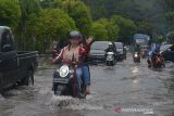 Banda Aceh Banjir Akibat Drainase Buruk. Sejumlah kendaraan menerobos jalan raya yang tergenang banjir akibat curtah hujan tinggi di pusat Kota Banda Aceh, Aceh, Senin (8/11/2021). Banjir yang menggenangi pusat kota Banda Aceh itu, akibat curah hujan tinggi yang hanya berlangsung sekitar satu jam dan selain buruknya drainase.ANTARA FOTO/Ampelsa.