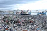  Kapal nelayan sandar di antara sampah yang berada di pantai pelabuhan Muncar, Banyuwangi, Jawa Timur, Selasa (9/11/2021). Sampah plastik dan tekstil yang terbawa air laut itu menumpuk di pantai sehingga menjadi masalah lingkungan yang bertahun-tahun belum teratasi. Antara Jatim/Budi Candra Setya/zk