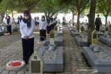 ZIARAH MAKAM HARI PAHLAWAN NASIONAL DENGAN PROKES. Prajurit TNI bersama warga menaburkan bunga saat zirah makam nasional  di Taman Makam Pahlawan, Banda Aceh, Aceh, Rabu (10/11/2021). Upacara ziarah makam dan dilanjutkan tabur bunga dengan penerapan protokol kesehatan di tengah COVID-19 itu dalam rangka memperingati Hari Pahlawan 10 November. ANTARA FOTO/Ampelsa