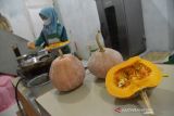 UMKM DONAT BERBAHAN PANGAN TRADISIONAL  BANGKIT DI TENGAH PANDEM. Perajin memproduksi kue donat berbahan pangan tradisional dari buah labu dan singkong di rumah UMKM Getlatela, Kampung Keuramat, Banda Aceh, Aceh, Jumat (12/11/2021). Pelaku UMKM binaan BUMN itu menyatakan produksi kue donat berbahan pangan tradisional buah labu dan singkong sejak setahun terakhir di tengah pandemi COVID-19 mulai bangkit setelah pemasarannya beralih menggunakan media online. ANTARA FOTO/Ampelsa.