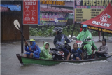 Sejumlah warga melintasi Jalan Lintas Melawi yang terdampak banjir dengan perahu di Ladang, Kabupaten Sintang, Kalimantan Barat, Jumat (12/11/2021). Banjir yang melanda 12 kecamatan tersebut belum juga surut selama tiga pekan terakhir akibat curah hujan yang tinggi, sementara pendistribusian bantuan masih terkendala di sejumlah wilayah karena sulitnya akses menuju lokasi. ANTARA FOTO/Abraham Mudito/app/aww.