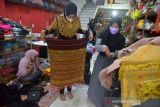 Perajin memperagakan busana penganten di salah satu UMKM Fashion Adat Aceh, Banda Aceh, Senin (15/11/2021). Pelaku usaha fashion di daerah itu menyatakan produksi busana penganten wanita dan juga pria dalam beberapa bulan terakhir di tengah pandemi COVID-19 berangsur normal dan begitu juga permintaan menyusul di beberapa daerah masyarakat sudah mulai menggelar kegiatan pesta perkawinan. ANTARA FOTO/Ampelsa.