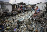 Sejumlah anak bermain di kawasan pemukiman warga pesisir Tanjung Uma, Batam, Kepulauan Riau, Senin (15/11/2021). Keberadaan sampah di kawasan pemukiman warga tersebut sebagian besarnya bawaan dari air laut ketika pasang. ANTARA FOTO/Teguh Prihatna/hp.
