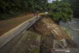 Warga melihat tebing jalan antardesa yang longsor di Kecamatan Batang Alai Timur, Kabupaten Hulu Sungai Tengah, Kalimantan Selatan, Rabu (17/11/2021). Tanah longsor yang terjadi pada Senin (15/11/2021) akibat hujan deras yang mengguyur daerah tersebut sempat menutup akses jalan warga serta dikhawatirkan terjadi longsor kembali jika hujan karena tanah yang masih labil. Foto Antaranews Kalsel/Bayu Pratama S.