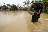 Warga memikul harta bendanya untuk keluar dari kepungan banjir di Desa Hagu, Kecamatan Matang Kuli, Aceh Utara, Aceh, Rabu (17/11/2021). Meluapnya Sungai Pirak dan Kereuto mengakibatkan 30 desa di empat kecamatan Aceh Utara terendam banjir hingga 150 centimeter dan mengakibatkan sebanyak 2.383 jiwa dilaporkan terdampak banjir. ANTARA FOTO/Rahmad