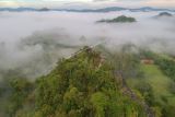 Foto udara kawasan wisata karst Bukit Tamulun, Desa Berkun, Limun, Sarolangun, Jambi, Rabu (17/11/2021). Karst Bukit Tamulun yang berada di hutan adat Tamulun Indah di bagian hulu Sungai Batang Limun merupakan salah satu wisata alam potensial namun tengah menghadapi ancaman perluasan aktivitas penambangan emas tanpa izin di bagian hilirnya. ANTARA FOTO/Wahdi Septiawan/wsj.