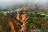 Foto udara longsoran tanah yang memutuskan jalan utama di Kawasan Wisata Darajat Pass, Kabupaten Garut, Jawa Barat, Sabtu (20/11/2021). Tanah longsor yang terjadi pada Jumat (19/11/2021) sore tersebut menyebabkan akses menuju Kawah Darajat terputus dan puluhan hektare lahan pertanian rusak. ANTARA FOTO/Raisan Al Farisi/agr