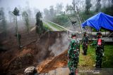 Sejumlah aparat TNI berjaga di sekitar longsoran tanah yang memutuskan jalan utama di Kawasan Wisata Darajat Pass, Kabupaten Garut, Jawa Barat, Sabtu (20/11/2021). Tanah longsor yang terjadi pada Jumat (19/11/2021) sore tersebut menyebabkan akses menuju Kawah Darajat terputus dan puluhan hektare lahan pertanian rusak. ANTARA FOTO/Raisan Al Farisi/agr