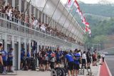 Penonton mengamati para kru tim bersiaga di paddock saat balapan pertama (race 1) kelas WorldSSP di Pertamina Mandalika International Street Circuit saat balapan WSBK seri Indonesia 2021 di Lombok Tengah, Nusa Tenggara Barat (NTB), Sabtu (20/11/2021). ANTARA FOTO/Andika Wahyu/foc.
