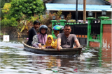 Sejumlah warga menaiki perahu motor saat melintasi banjir di Kelurahan Ulak Jaya, Sintang, Kalimantan Barat, Minggu (21/11/2021). Banjir yang melanda kelurahan Ulak Jaya selama hampir empat pekan dengan ketinggian air dua meter tersebut sudah semakin surut. ANTARA FOTO/Jessica Helena Wuysang/pras. 