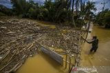 Warga melihat sampah yang menumpuk di sungai di Desa Masiraan, Kabupaten Hulu Sungai Tengah, Kalimantan Selatan, Sabtu (20/11/2021). Warga keluhkan penanganan pemerintah daerah terhadap sampah yang menyebabkan penyumbatan aliran sungai sehingga banjir tak kunjung surut. Foto Antaranews Kalsel/Bayu Pratama S.