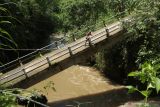Warga melewati jembatan yang terputus di Glenmore, Banyuwangi, Jawa Timur, Rabu (24/11/2021). Jembatan penghubung Desa Tegalharjo dan Karangharjo yang terputus akibat arus sungai Kalibaru meningkat dampak curah hujan tinggi itu menyebabkan warga sekitar kesulitan akses jalan karena harus memutar 3 kilometer dengan medan jalan yang rusak. Antara Jatim/Budi Candra Setya/zk