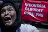 Massa yang tergabung dalam Aliansi Forum Guru Bandung Raya melakukan aksi teatrikal saat unjuk rasa Indonesia Darurat Guru PNS di Monumen Perjuangan Rakyat, Bandung, Jawa Barat, Kamis (25/11/2021). Aksi dalam rangka memperingati Hari Guru Nasional tersebut meminta Pemerintah Indonesia segera mengangkat guru honorer di sekolah negeri ataupun swasta menjadi PNS dan memberi kesempatan untuk PPG serta memberikan gaji diatas upah minimum regional. ANTARA FOTO/Novrian Arbi/agr