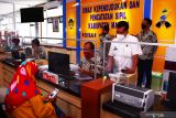 Petugas Dinas Kependudukan dan Pencatatan Sipil (Dispendukcapil) melayani warga yang mengurus dokumen kependudukan di Mal Pelayanan Publik Kabupaten Madiun, Jawa Timur, Rabu (24/11/2021). Dispendukcapil Kabupaten Madiun meningkatkan layanan di mal pelayanan publik antara lain menyediakan Anjungan Dukcapil Mandiri (ADM) guna memberikan kemudahan, kecepatan dan kenyamanan warga yang mengurus dokumen kependudukan. Antara Jatim/Siswowidodo/zk