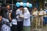 Sejumlah siswa memberikan hadiah kado kue ulang tahun kepada guru mereka saat memeriahkan peringatan Hari Guru Nasional di Sekolah Menengah Kejuruan (SMK) Banda Aceh, Aceh, Kamis (25/11/2021). Peringatan Hari Guru Nasional yang berlangsung di sejumlah sekolah dalam situasi pandemi COVID-19 di daerah  itu dimeriahkan dengan berbagai kegiatan secara sederhana. ANTARA FOTO/Ampelsa