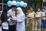 Sejumlah siswa memberikan hadiah kado kue ulang tahun kepada guru mereka saat memeriahkan peringatan Hari Guru Nasional di Sekolah Menengah Kejuruan (SMK) Banda Aceh, Aceh, Kamis (25/11/2021). Peringatan Hari Guru Nasional yang berlangsung di sejumlah sekolah dalam situasi pandemi COVID-19 di daerah  itu dimeriahkan dengan berbagai kegiatan secara sederhana. ANTARA FOTO/Ampelsa