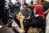 Anggiat Pasaribu (kiri) meminta maaf kepada Ibunda Arteria Dahlan, Wasniar (kanan) yang disaksikan Anggota Komisi III DPR Arteria Dahlan (tengah) saat upaya mediasi di Kompleks Parlemen, Senayan, Jakarta, Kamis (25/11/2021). Dalam mediasi tersebut Anggiat Pasaribu meminta maaf secara langsung kepada Ibunda Arteria Dahlan terkait kasus cekcok di Bandara Internasional Soekarno Hatta, Banten pada Minggu (21/11/2021) lalu yang videonya sempat viral di sosial media. ANTARA FOTO/Muhammad Adimaja/nym.