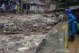 Warga merobohkan jembatan penghubung yang dipenuhi sampah pada aliran sungai Cipagalo yang meluap di Kawasan Sukamiskin, Bandung, Jawa Barat, Jumat (26/11/2021). Warga kawasan tersebut membongkar jembatan penghubung akibat besarnya volume air dan sampah saat intensitas hujan tinggi agar tidak meluap ke permukiman. ANTARA FOTO/Novrian Arbi/agr