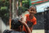 Dua anak bermain saat hujan di Depok, Jawa Barat, Sabtu (27/11/2021). BMKG memprediksi Badai La Nina akan memasuki Indonesia pada November 2021 hingga Februari 2022 mendatang, La Nina tahun ini diprediksikan relatif sama dan akan berdampak pada peningkatan curah hujan bulanan berkisar antara 20 - 70 persen di atas normalnya. ANTARA FOTO/Yulius Satria Wijaya/hp. 