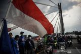 Ratusan buruh konvoi melintasi Jembatan Pasupati saat melakukan aksi di Bandung, Jawa Barat, Senin (29/11/2021). Aksi buruh yang tergabung dari berbagai aliansi di Jawa Barat tersebut ditujukan untuk mengawal penetapan UMK oleh Pemprov Jabar. ANTARA FOTO/Raisan Al Farisi/agr
