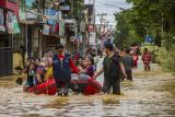 Relawan mengevakuasi warga yang terdampak banjir di Barabai, Kabupaten Hulu Sungai Tengah, Kalimantan Selatan, Senin (29/11/2021). Berdasarkan data sementara dari Badan Penanggulangan Bencana Daerah (BPBD) Kabupaten Hulu Sungai Tengah sebanyak 3.944 jiwa mengungsi akibat terdampak banjir. ANTARA FOTO/Bayu Pratama S/nym.