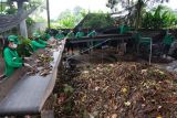 Petugas Dinas Lingkungan Hidup dan Kebersihan (DLHK) Kota Denpasar mengolah sampah organik menjadi pupuk kompos menggunakan mesin di Tempat Pembuangan Sampah Terpadu (TPST) Desa Kesiman Kertalangu, Denpasar, Bali, Rabu (1/12/2021). Tempat pembuangan sampah tersebut dalam sehari mampu mengolah 3 ton sampah organik menjadi pupuk kompos dan pupuk hasil pengolahan itu dibagikan secara gratis kepada masyarakat, komunitas dan sekolah yang membutuhkan. ANTARA FOTO/Nyoman Hendra Wibowo/nym.