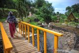 Warga melintasi sebuah jembatan di Taman Wisata Air Cisurupan, Cilengkrang, Bandung, Jawa Barat, Jumat (3/12/2021). Pemerintah Kota Bandung meresmikan Taman Wisata Air yang diberinama 
