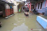 Warga beraktivitas saat terjadi banjir rob yang melanda desa Eretan Wetan, Kandanghaur, Indramayu, Jawa Barat, Sabtu (4/12/2021). Badan Meteorologi, Klimatologi dan Geofisika (BMKG) memprediksi banjir rob di pesisir pantai utara akan terjadi hingga 9 Desember mendatang. ANTARA FOTO/Dedhez Anggara/agr